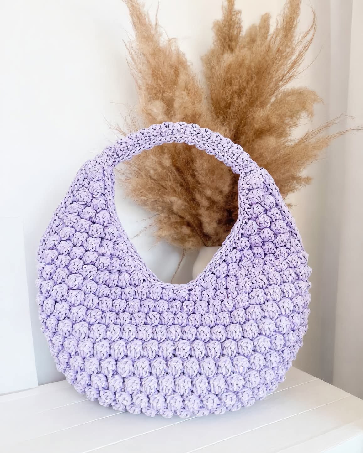 Gros plan sur la texture d'un sac QOFFA en cours de crochet